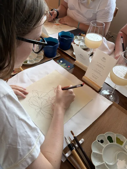 A guest drawing linework, brushes at hand